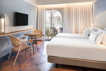 a room with two beds and a table and chairs