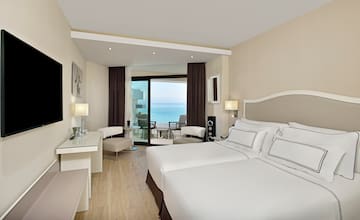 a room with a large bed and a table and chairs