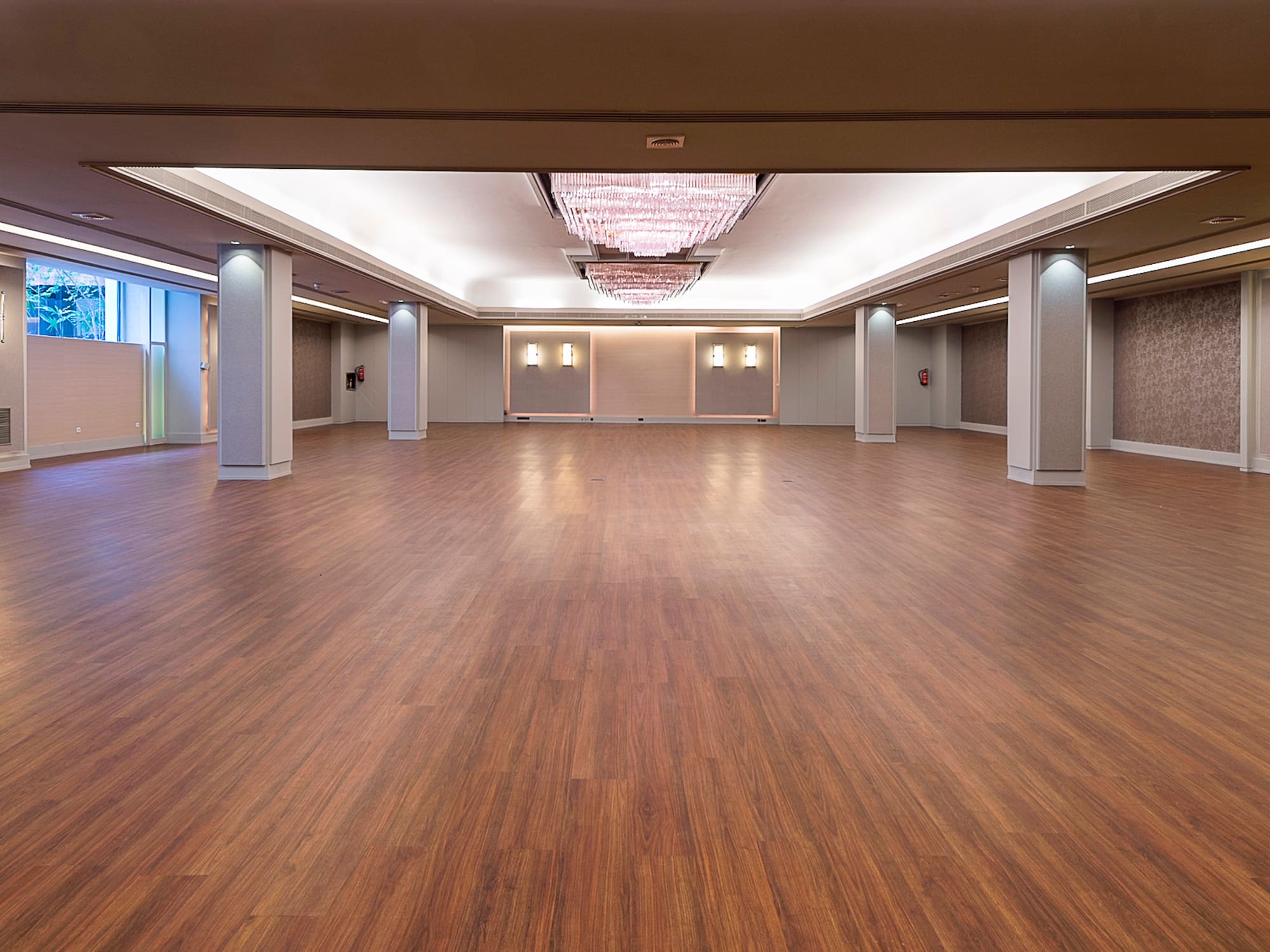 a large room with wood floors and ceiling lights