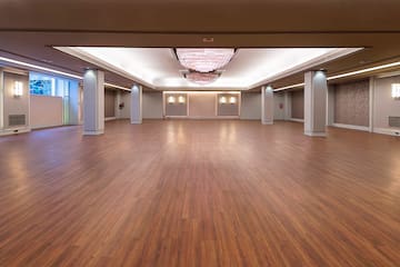a large room with wood floors and ceiling lights