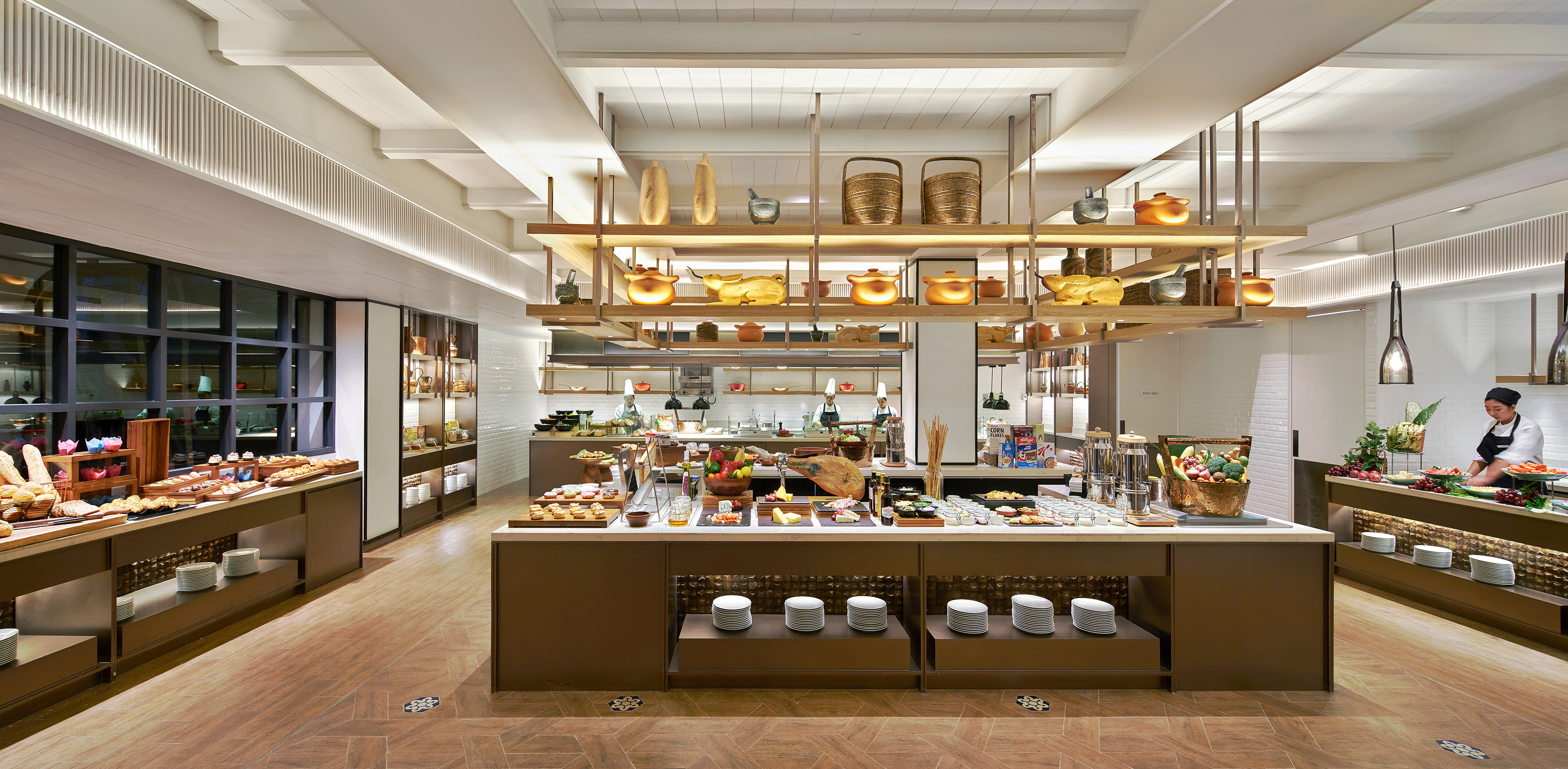 Hotel breakfast buffet with fresh food stations, pastries, and chefs.