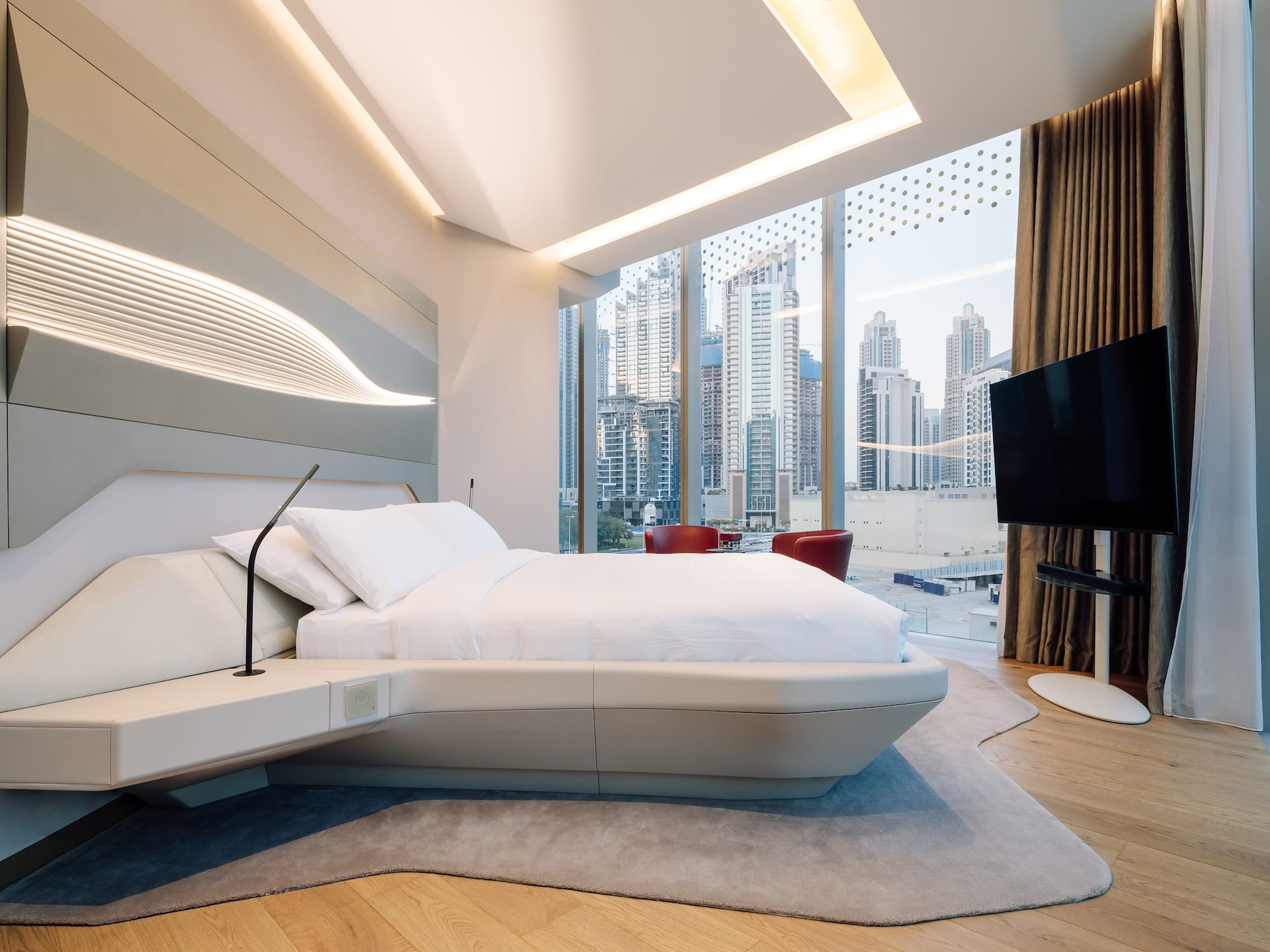 a bedroom with a large window and a large bed