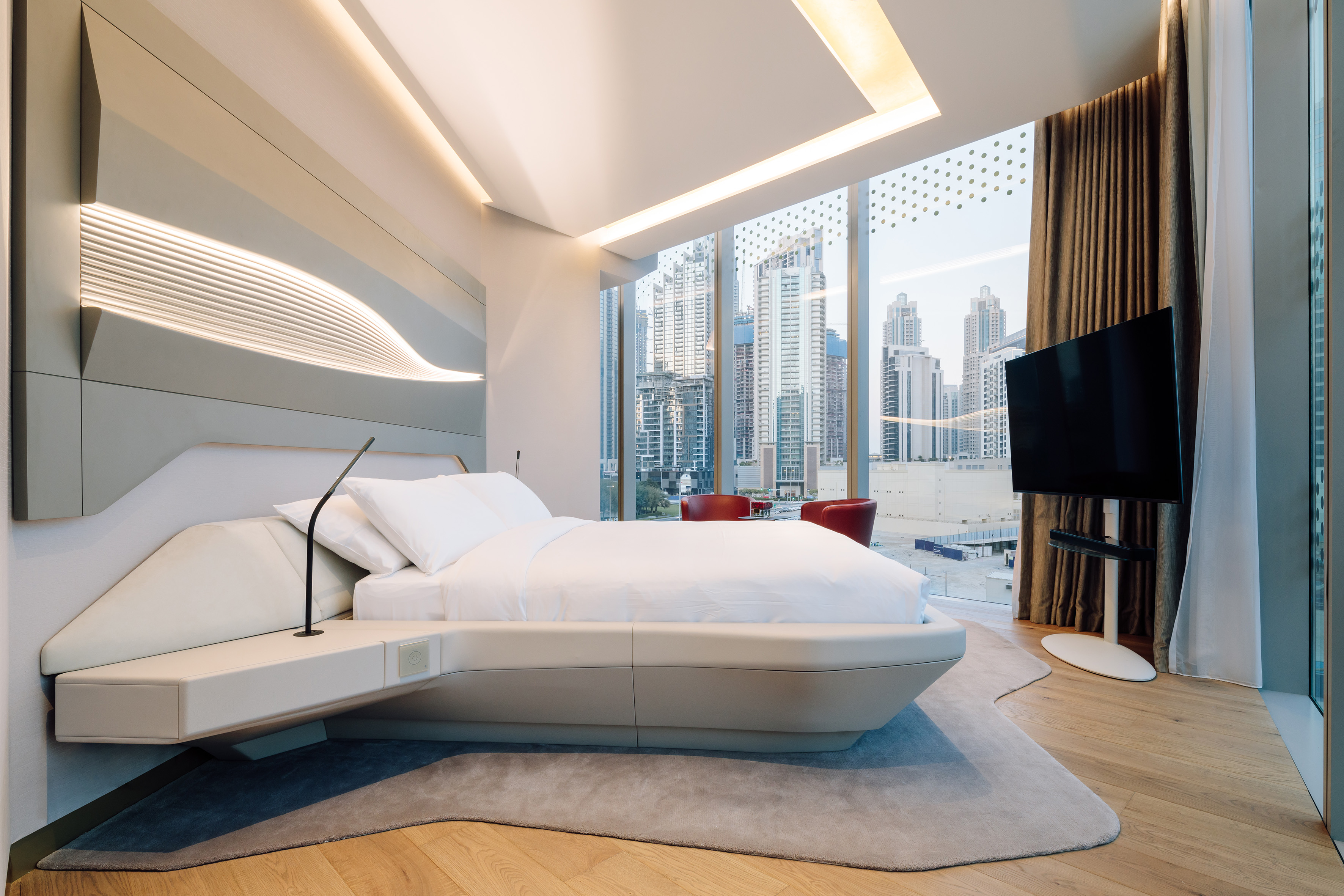 a bedroom with a large window and a large bed