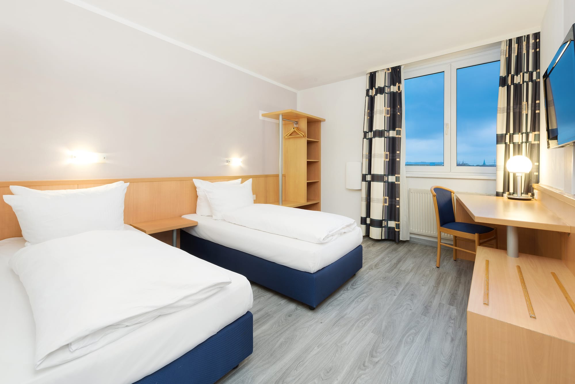 a room with two beds and a desk