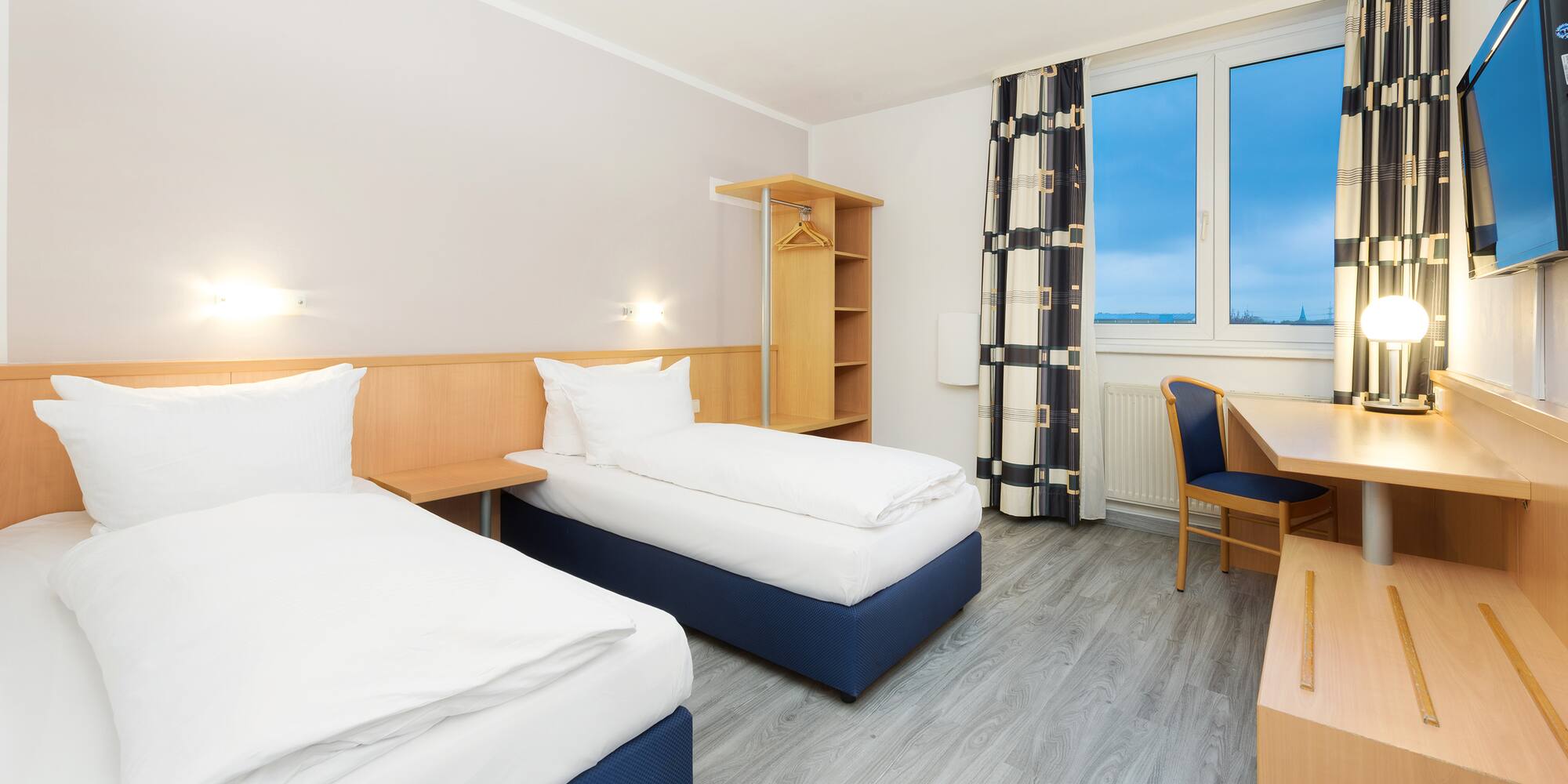 a room with two beds and a desk