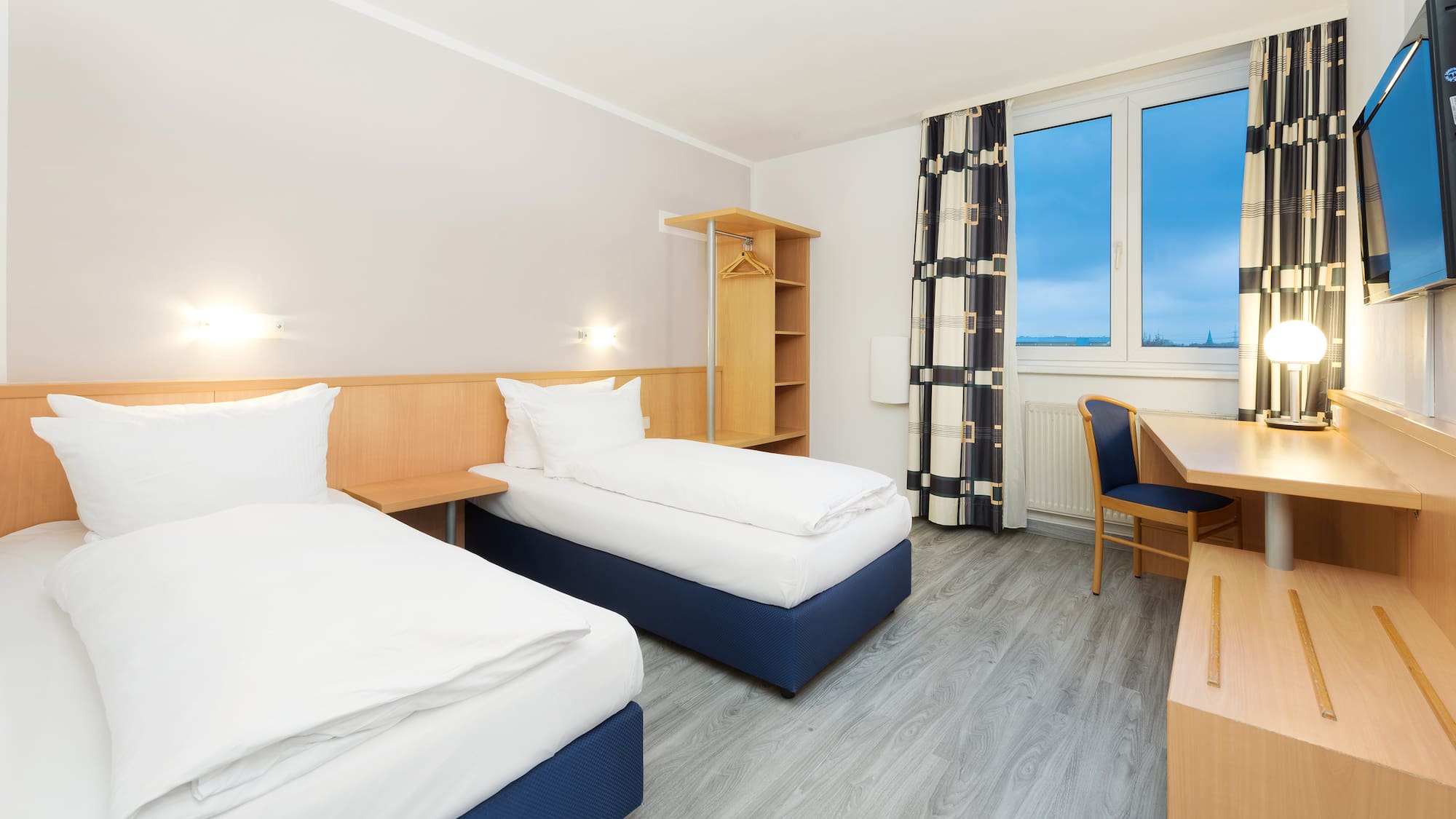 a room with two beds and a desk