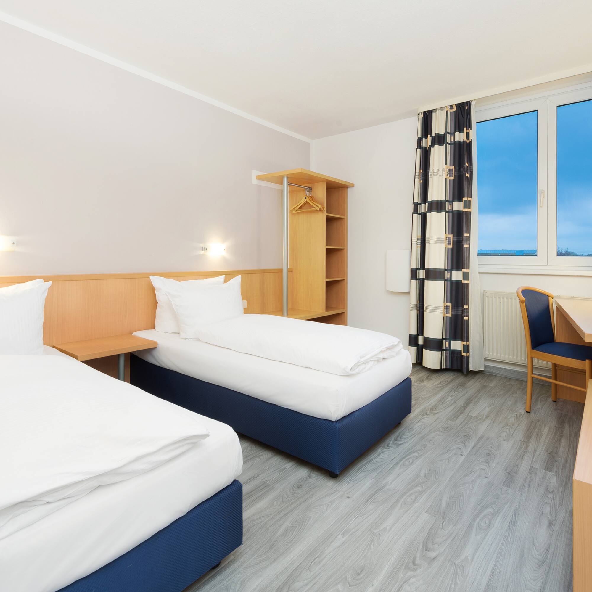 a room with two beds and a desk