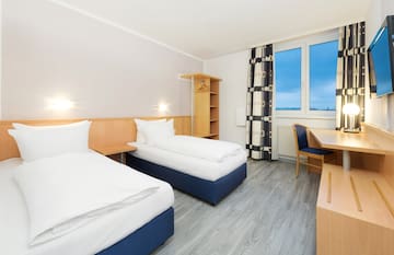 a room with two beds and a desk