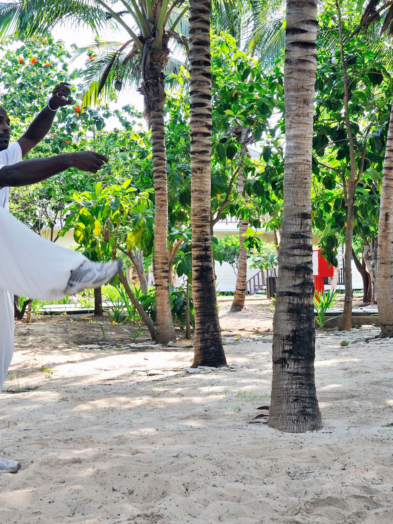 a man standing on one leg in front of trees