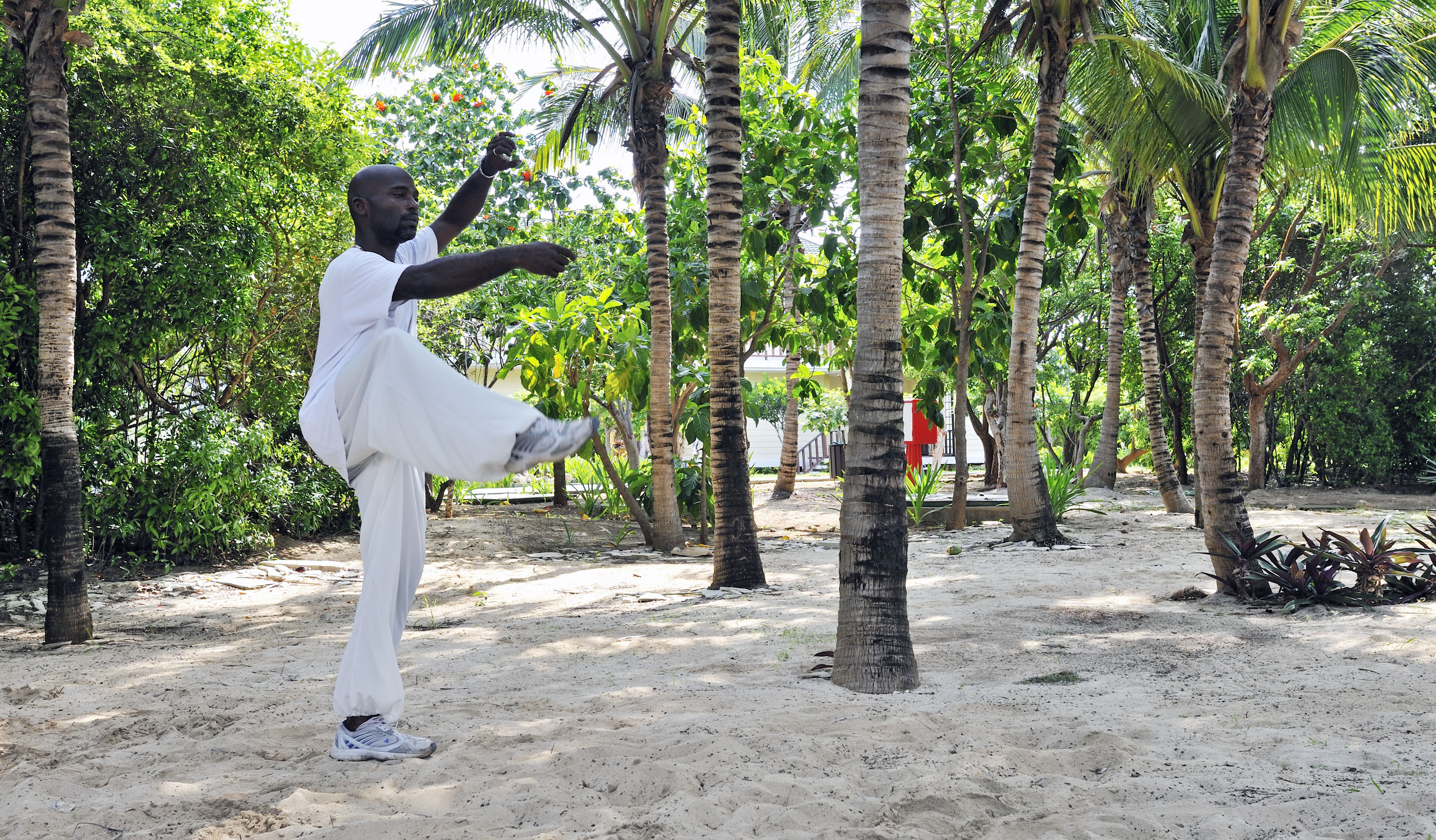 a man standing on one leg in front of trees