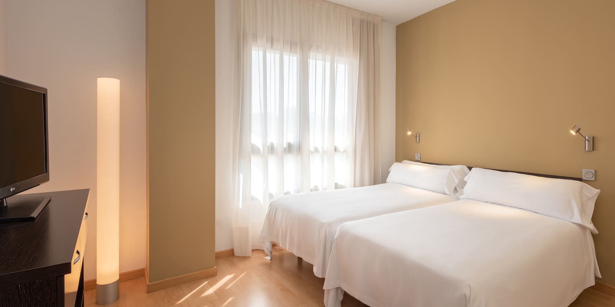 a room with two beds and a lamp