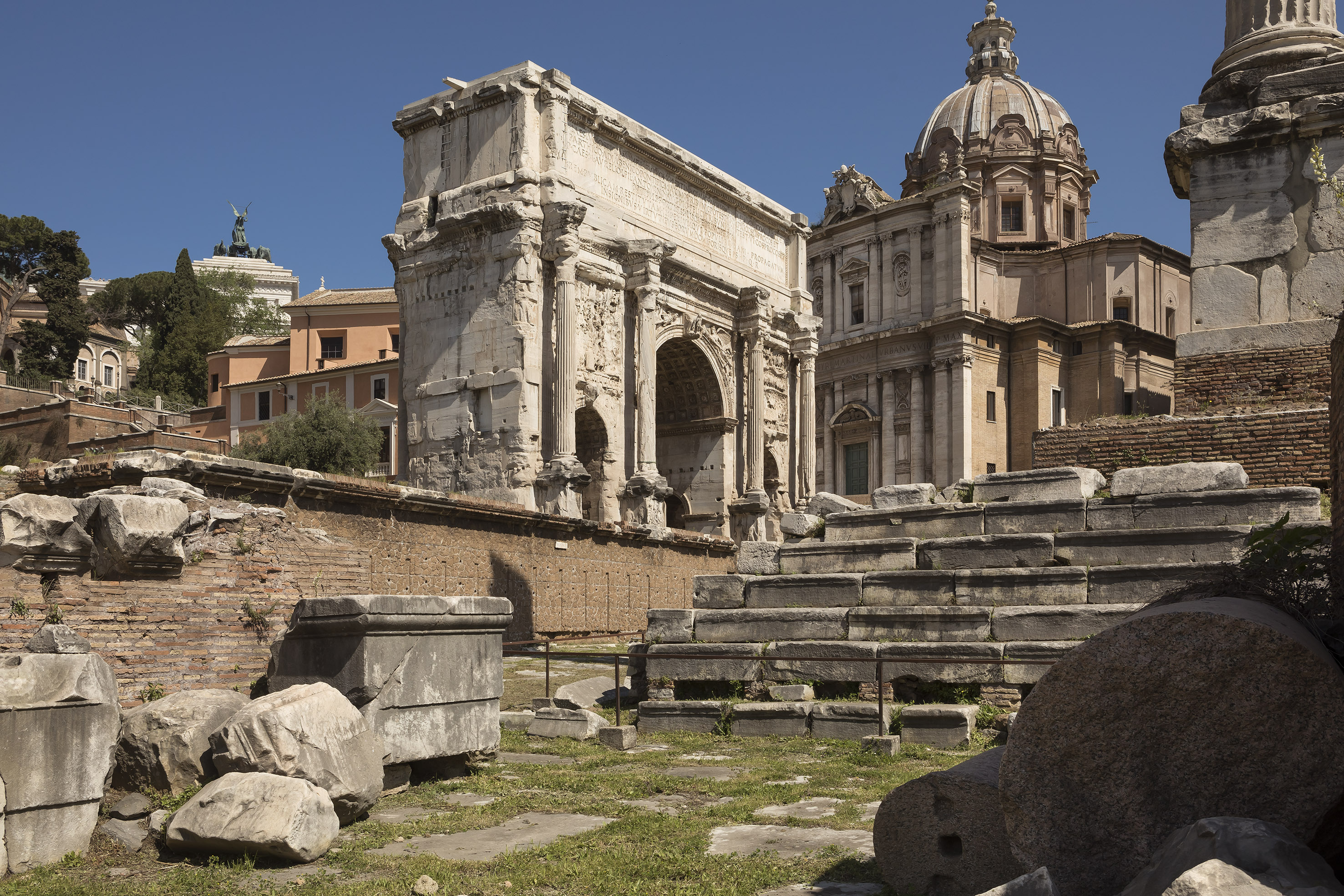Arch of Septimius Severus, Roman Forum, and domed church in ancient Rome.