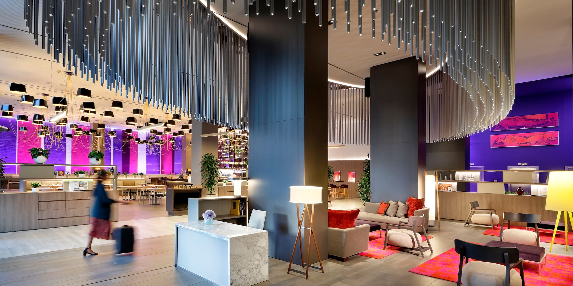 a lobby with a large chandelier and a couple of people walking