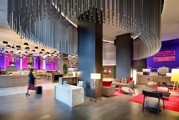 a lobby with a large chandelier and a couple of people walking