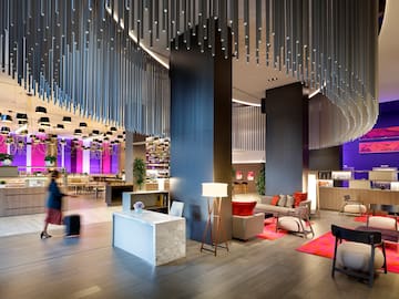 a lobby with a large chandelier and a couple of people walking