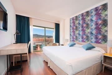 a room with a bed and a table and chairs