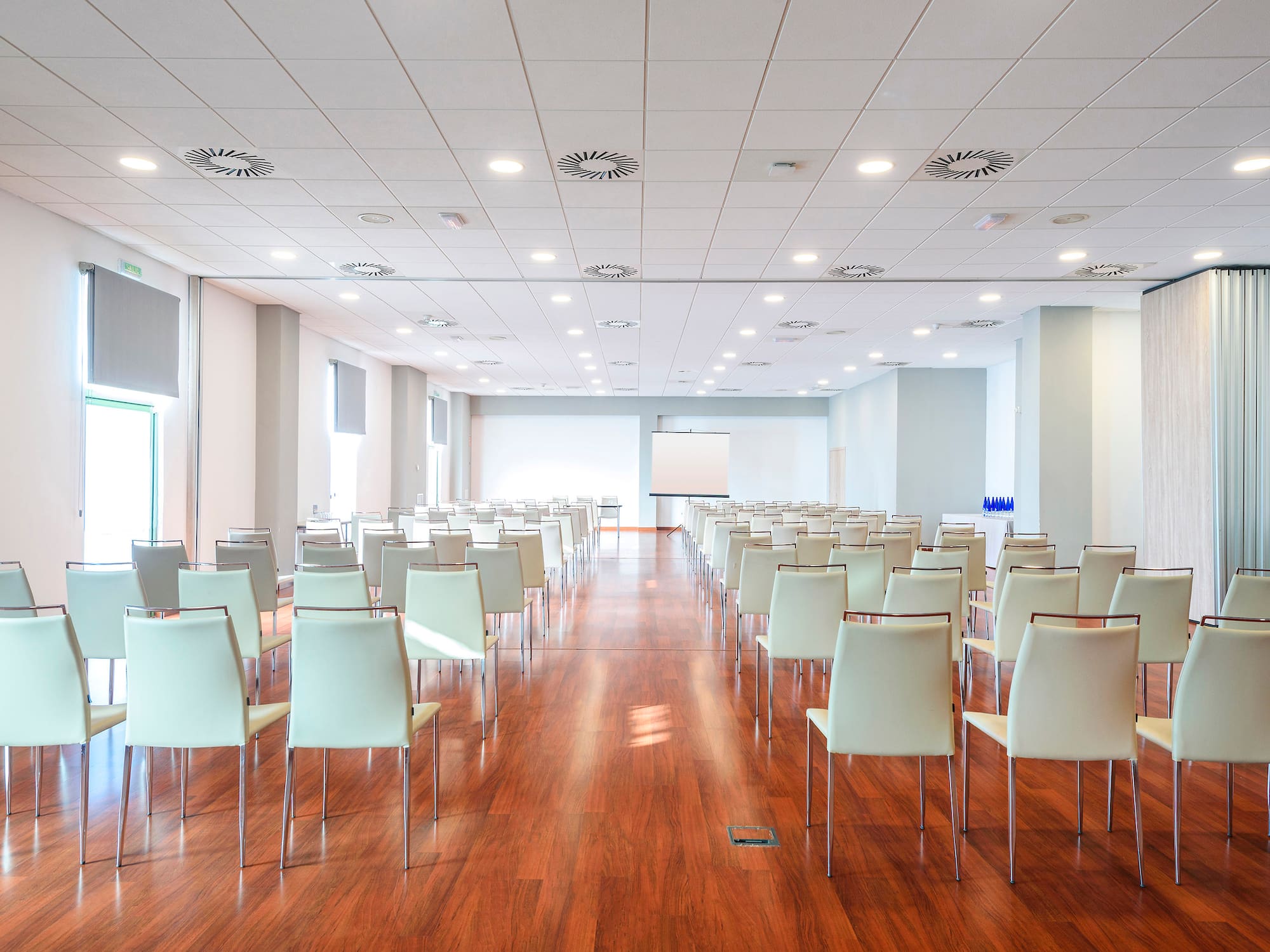 a room with white chairs and a wood floor