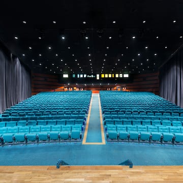 a large auditorium with blue seats