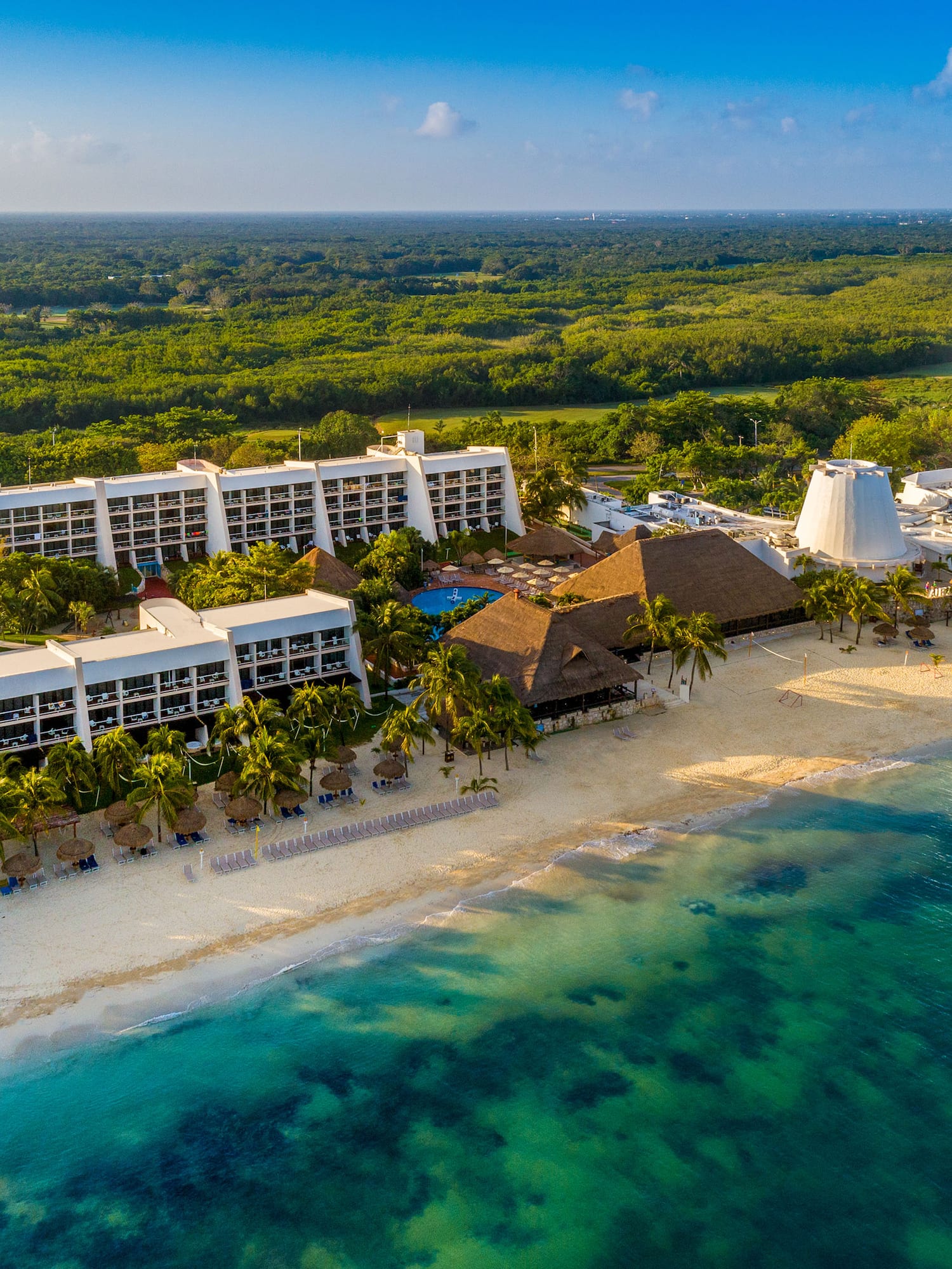 a beach with a group of buildings and trees