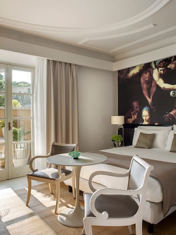a room with a bed and chairs