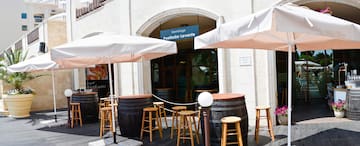 a group of stools and umbrellas outside of a building