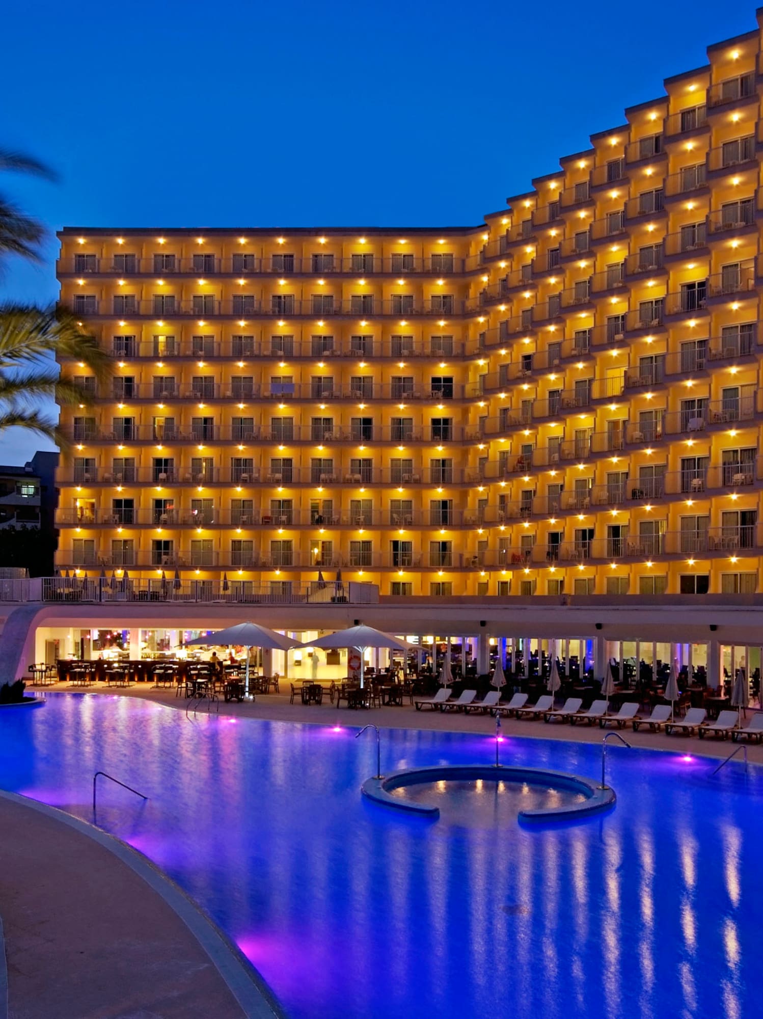 a large hotel with a pool and palm trees