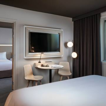 a room with a bed and a table and chairs