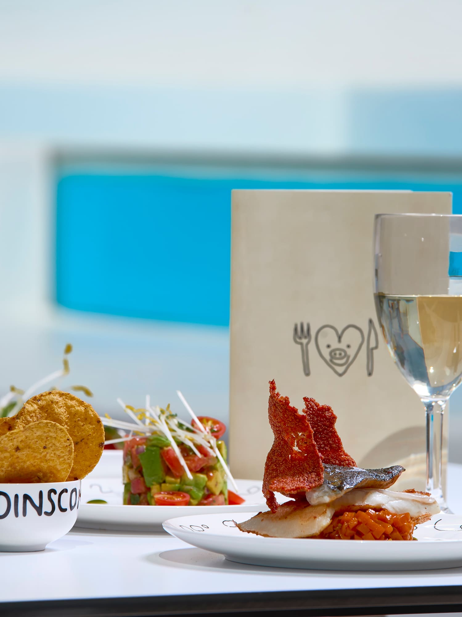 a table with plates of food and a glass of wine