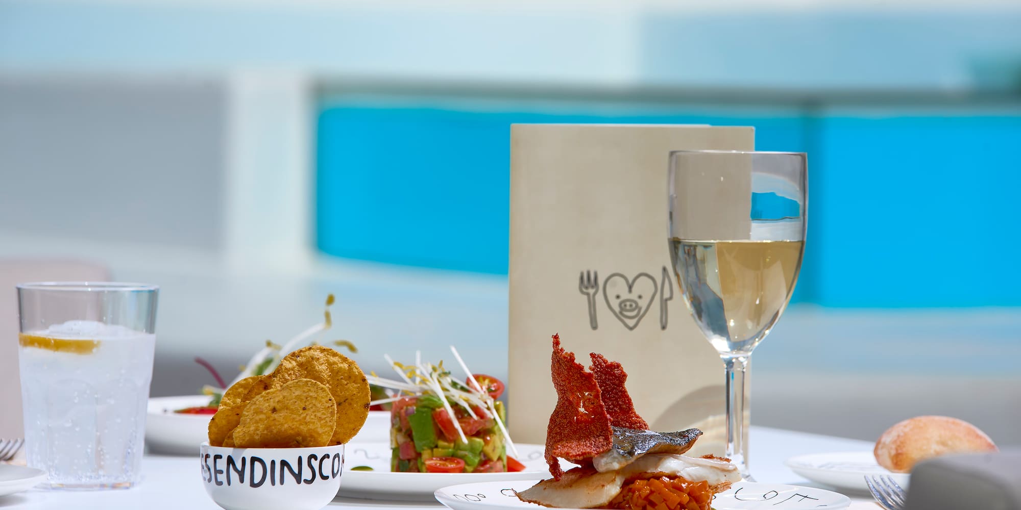 a table with plates of food and a glass of wine