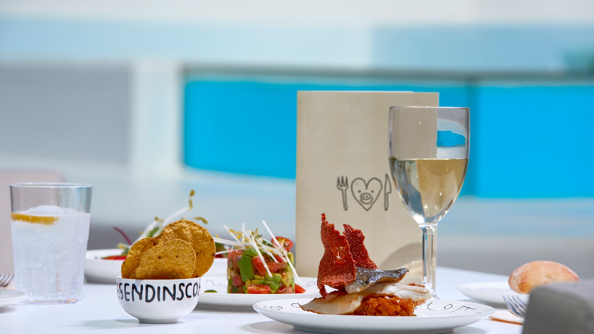 a table with plates of food and a glass of wine