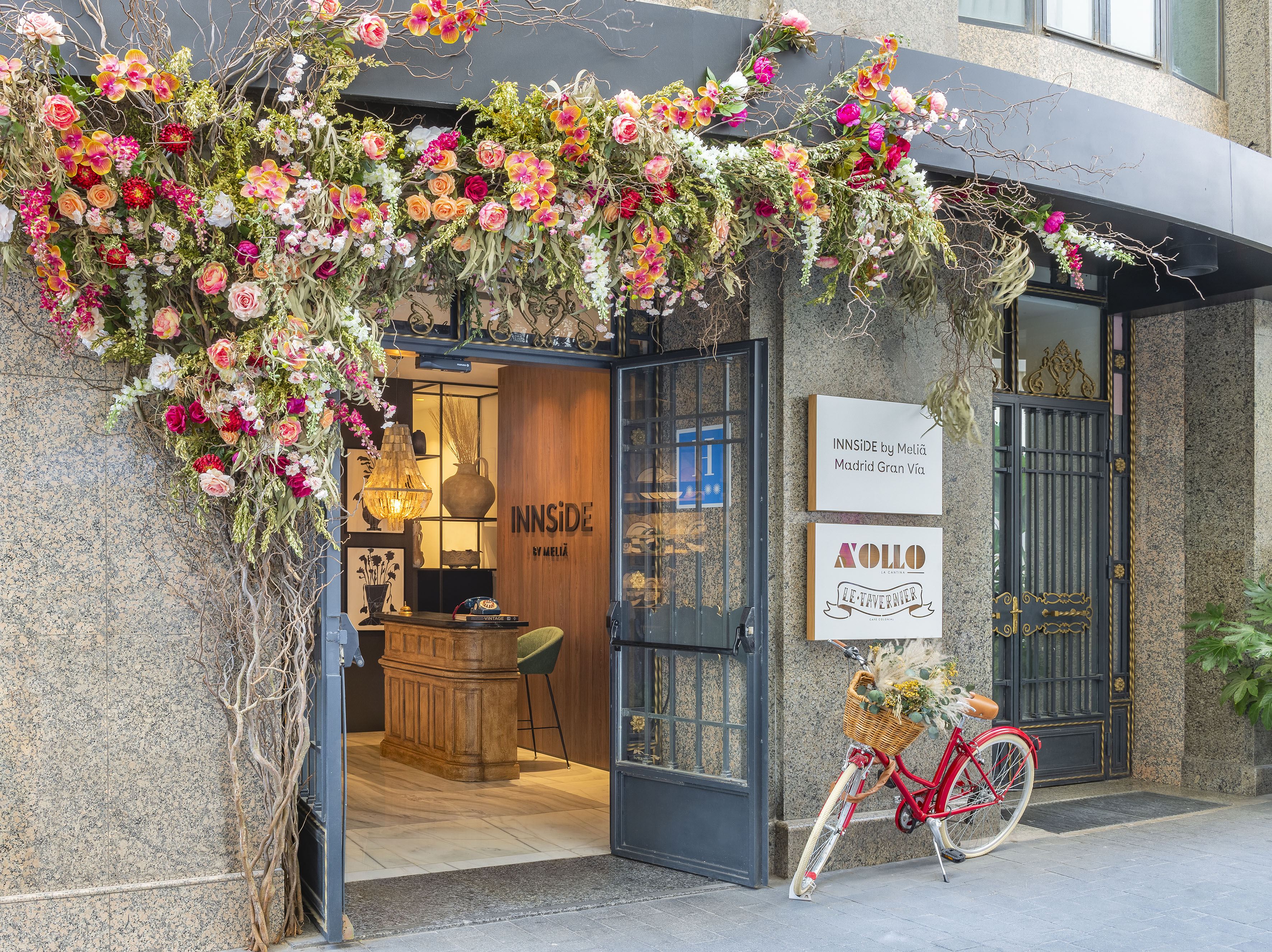 INNSIDE Madrid Gran Vía hotel entrance, abundant flowers, red bicycle.