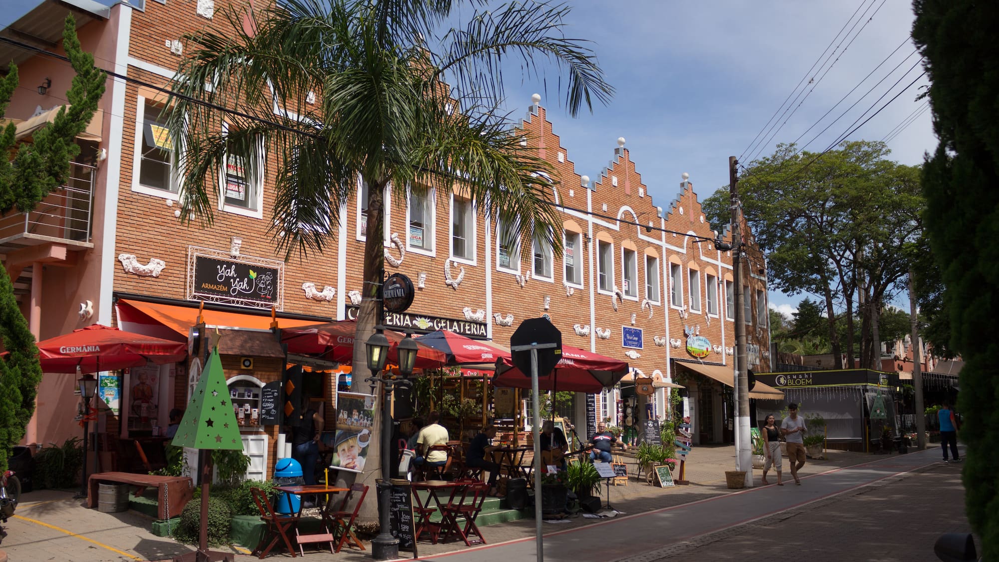a building with a palm tree and people walking on the street