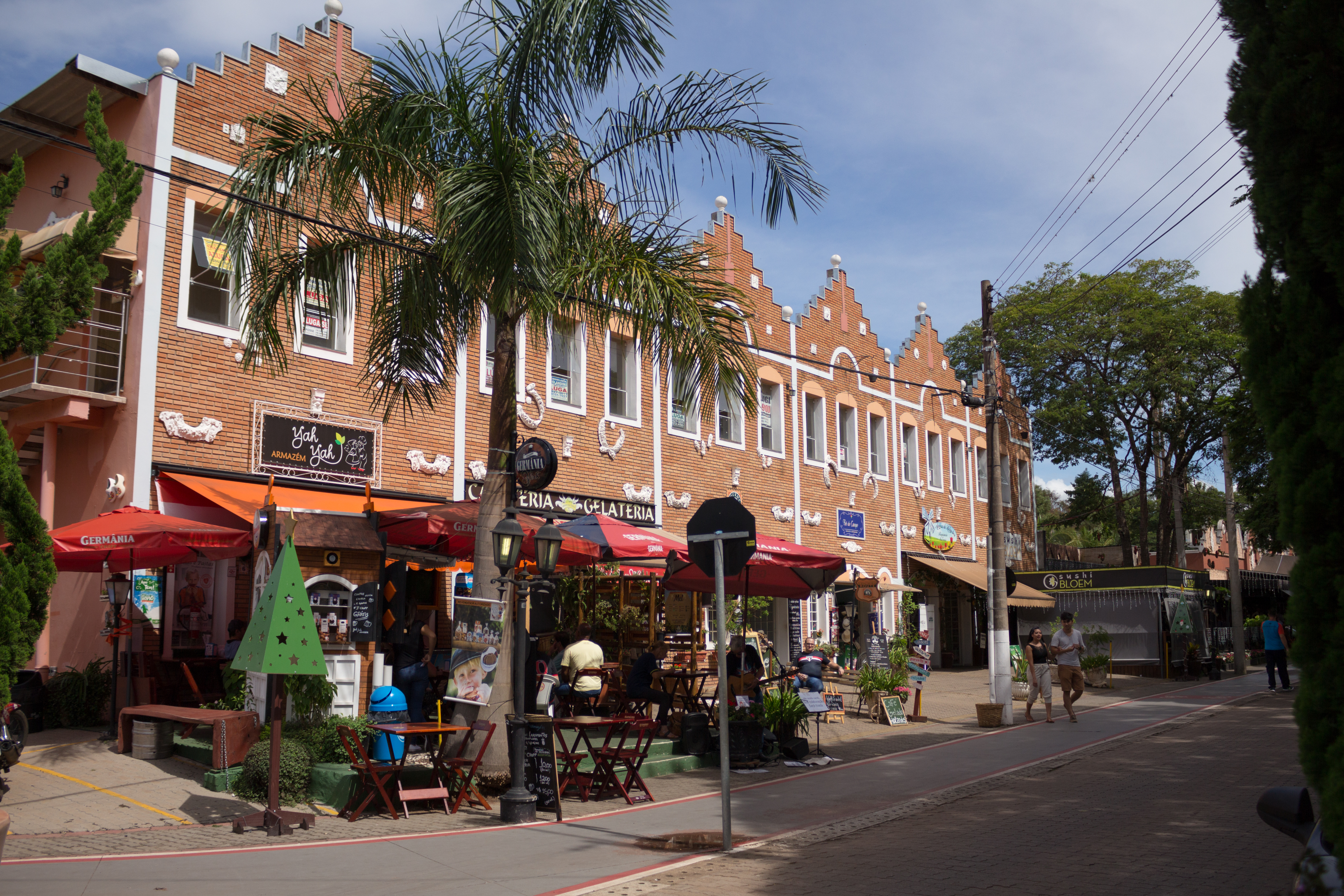 a building with a palm tree and people walking on the street