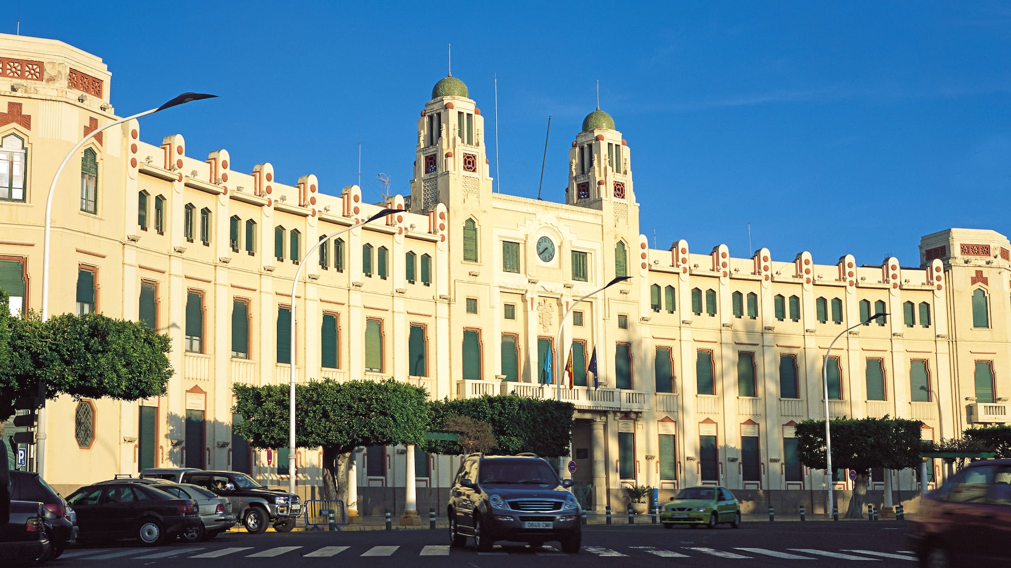 a large building with many windows and cars parked in front of it