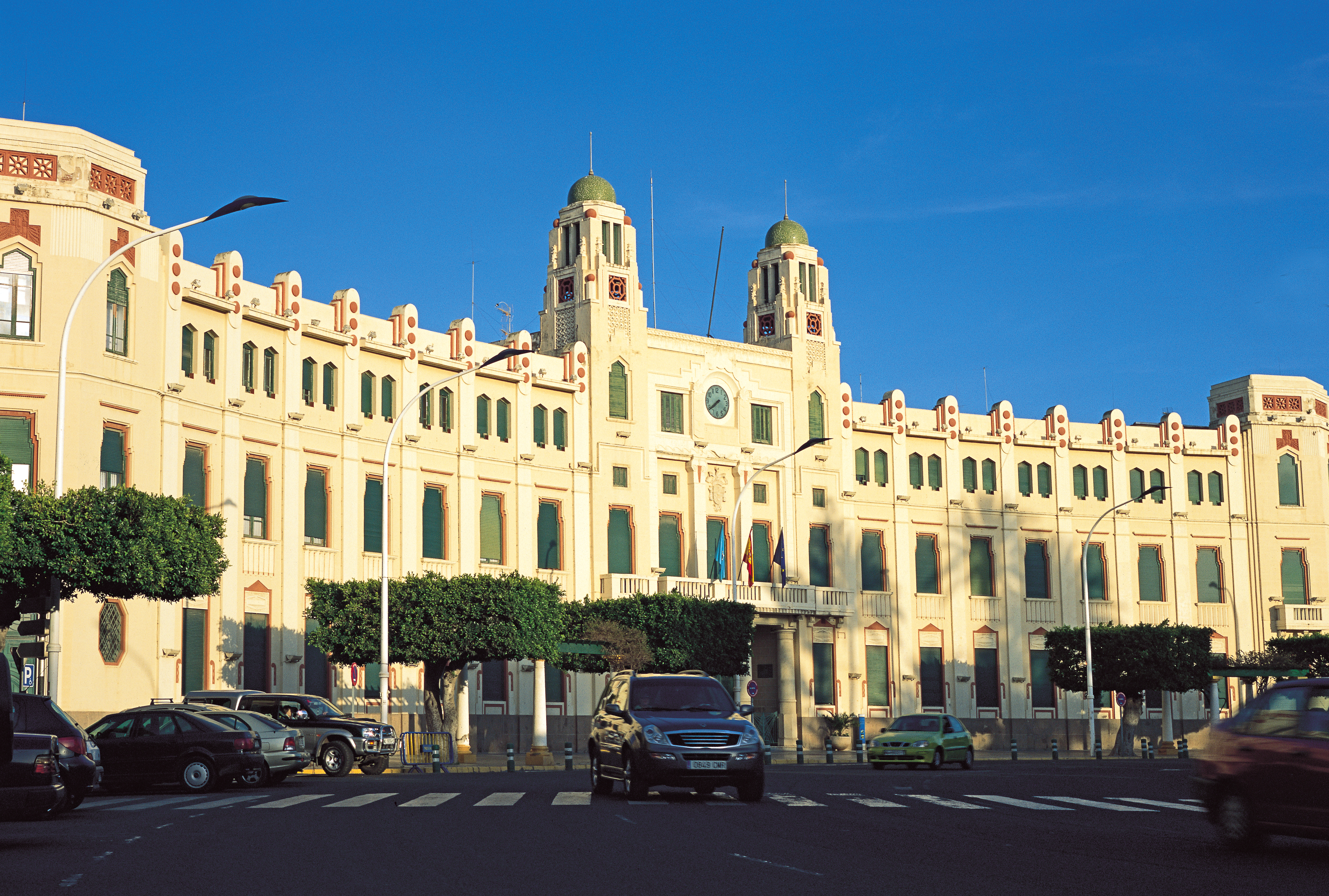 a large building with many windows and cars parked in front of it