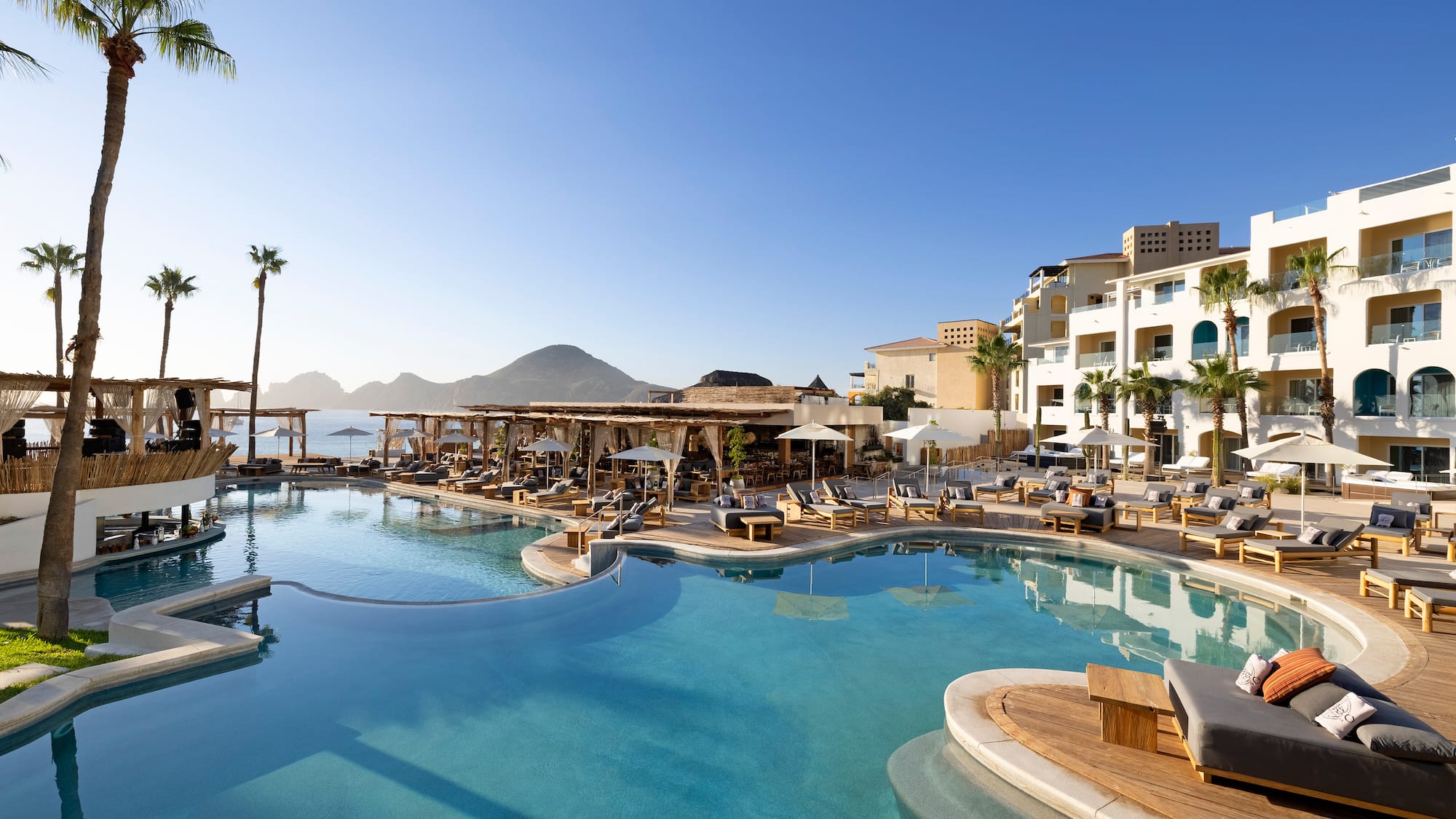 a swimming pool with chairs and a building in the background