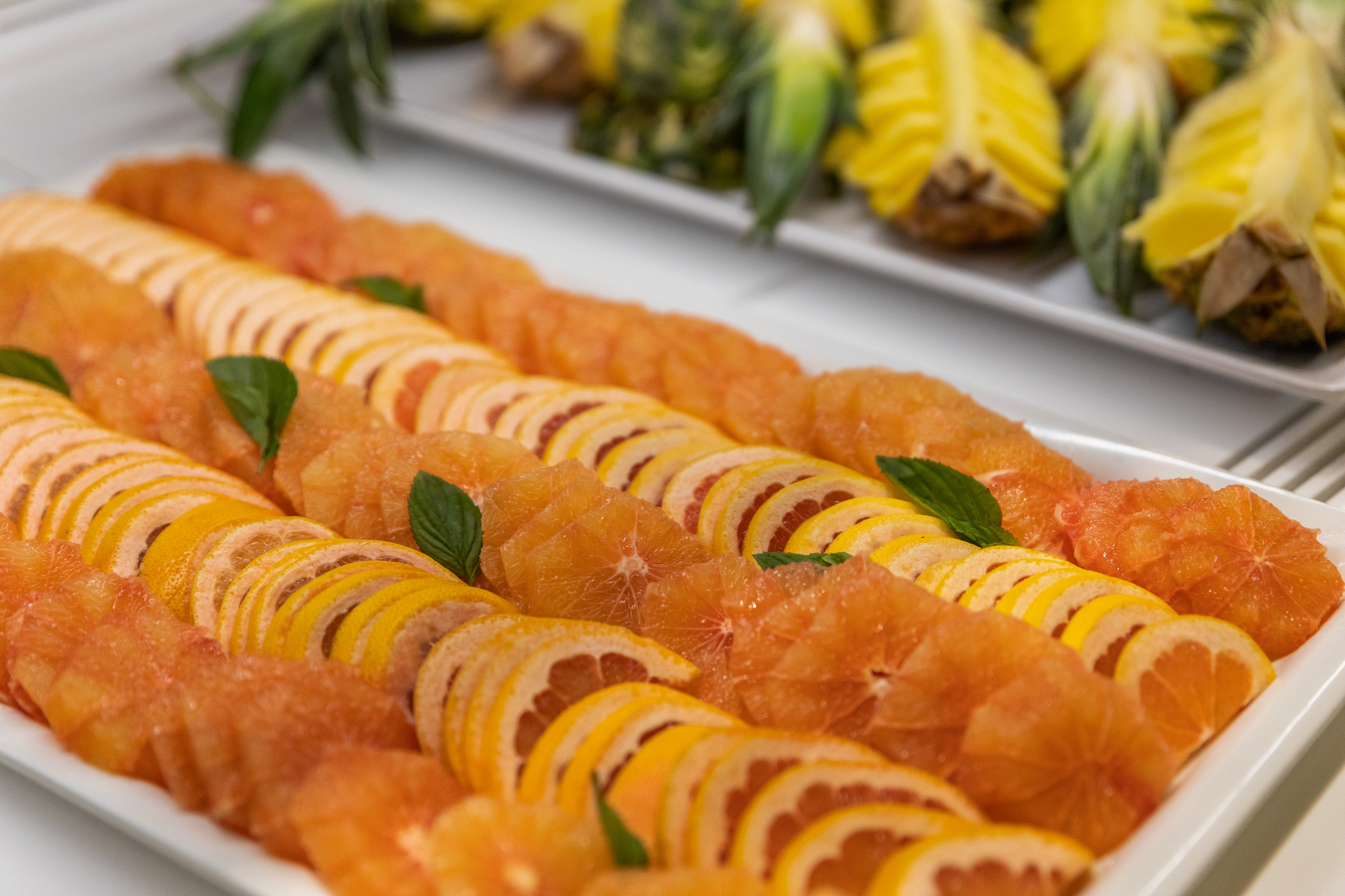 Fresh sliced pink and yellow grapefruit platter with mint garnish.