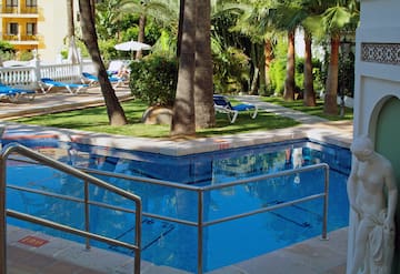 a pool with a metal railing and palm trees