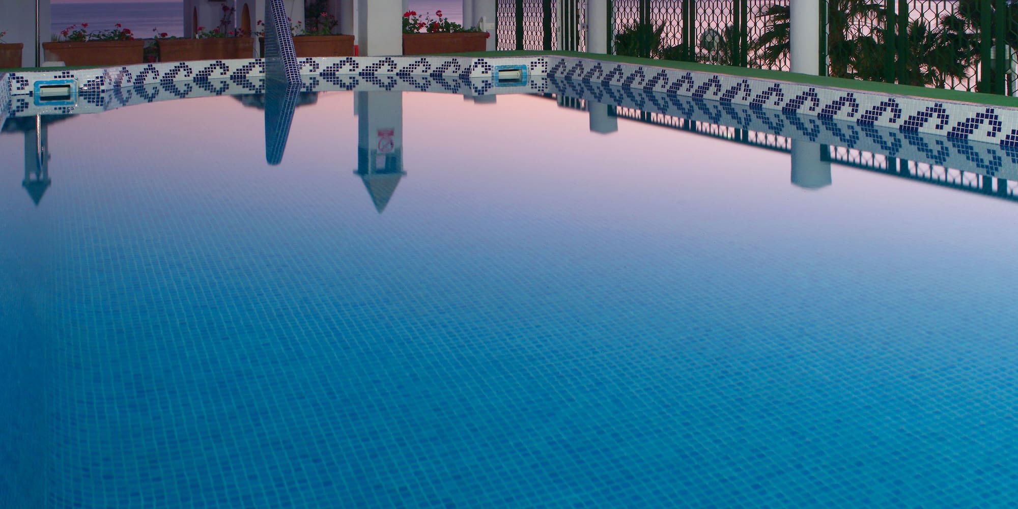 a pool with a fence and a building