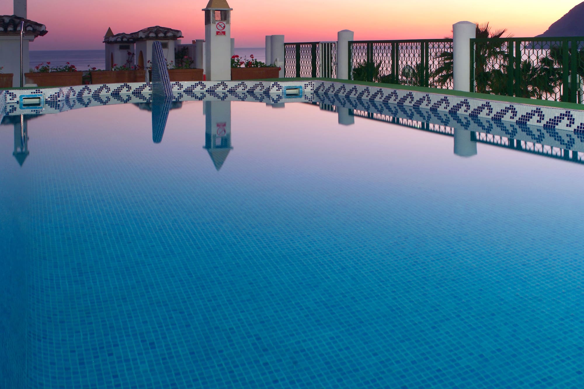 a pool with a fence and a building