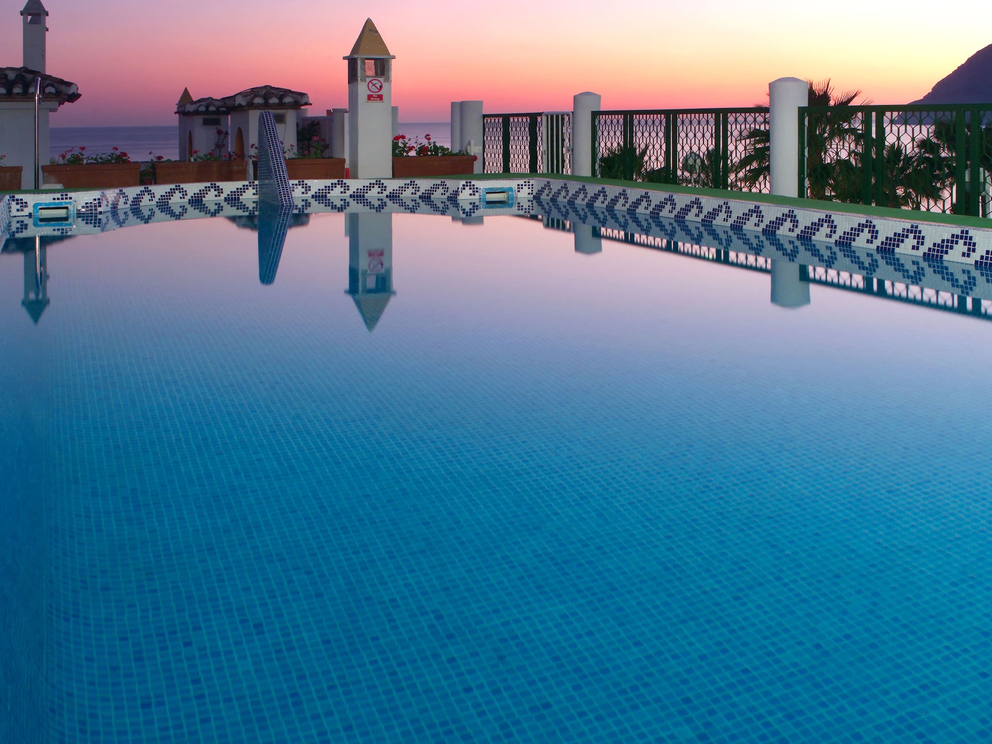 a pool with a fence and a building