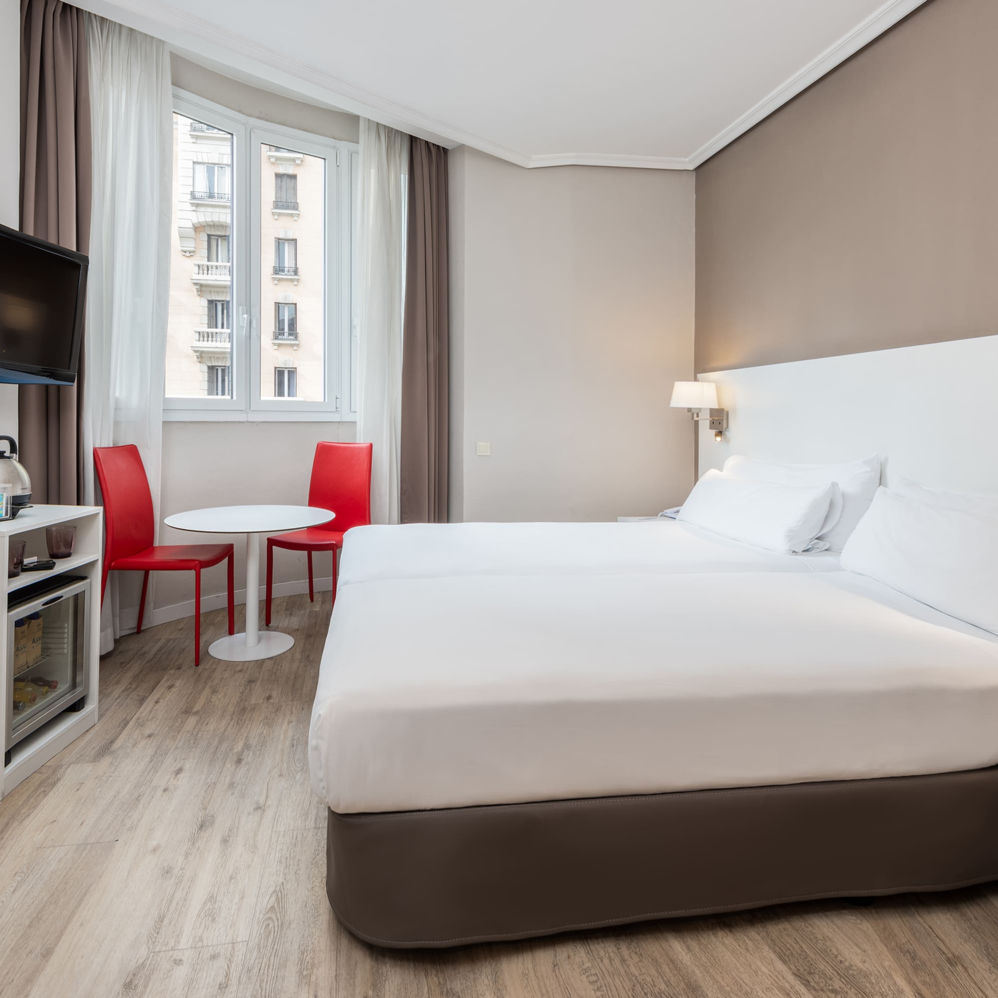 a room with two beds and a tv