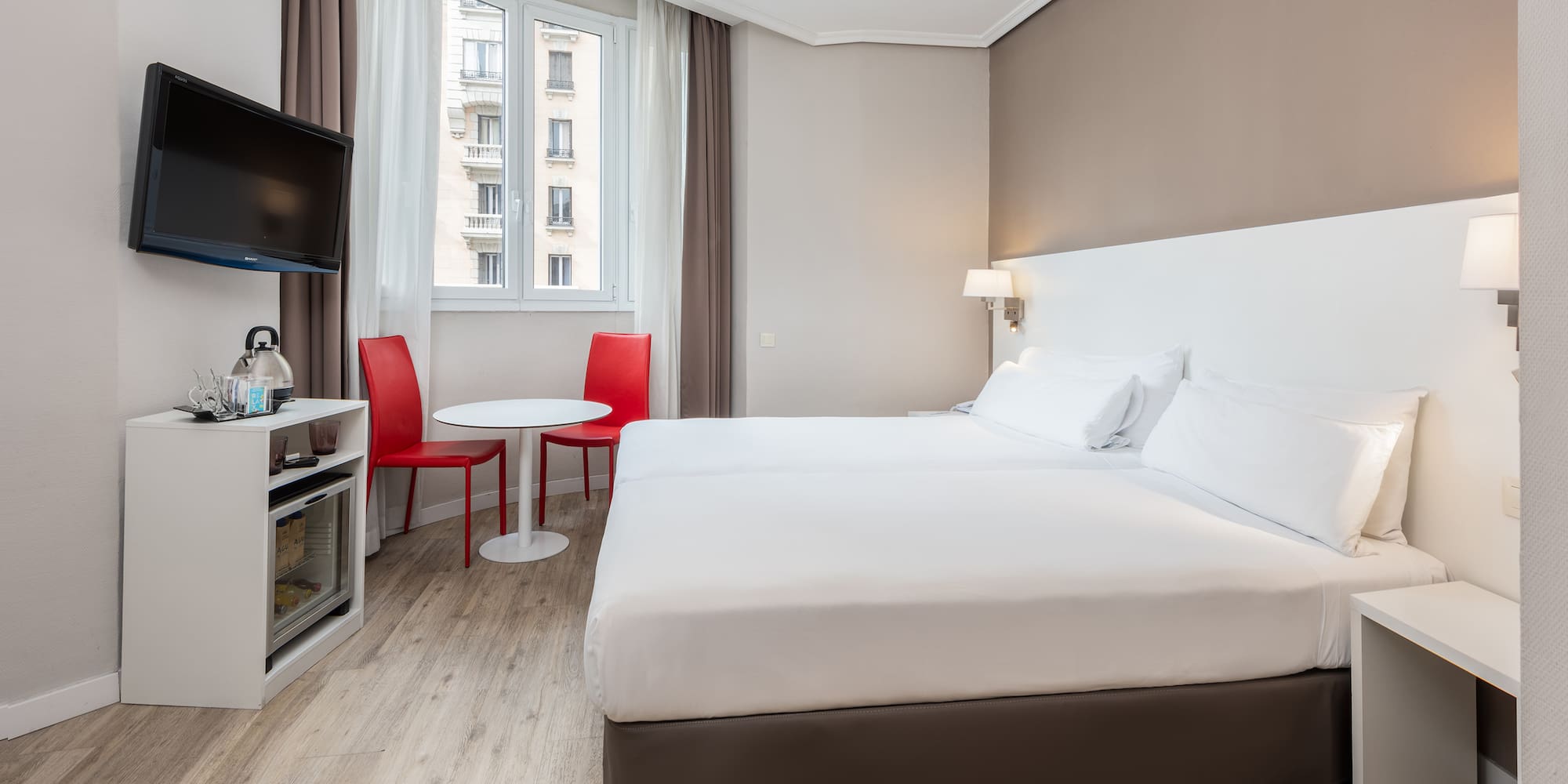 a room with two beds and a tv