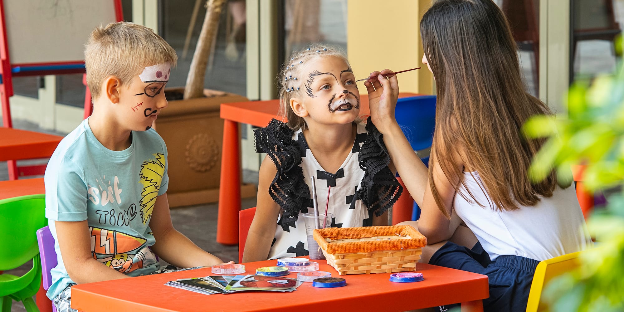 a group of children painting on their faces