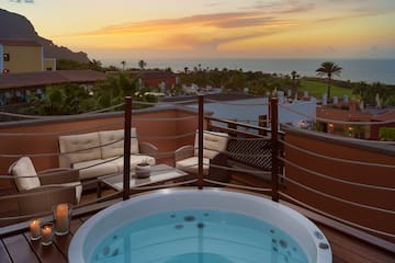 a hot tub on a deck overlooking a body of water