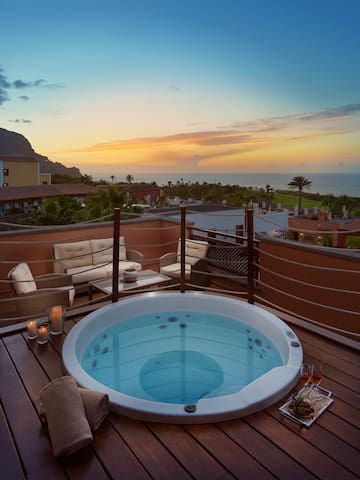 a hot tub on a deck overlooking a body of water