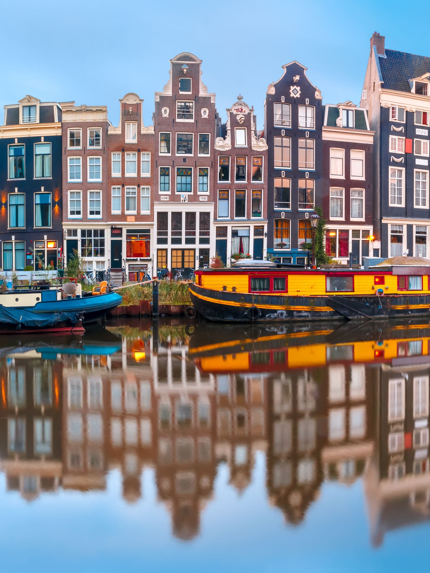 boats on the water next to a row of buildings