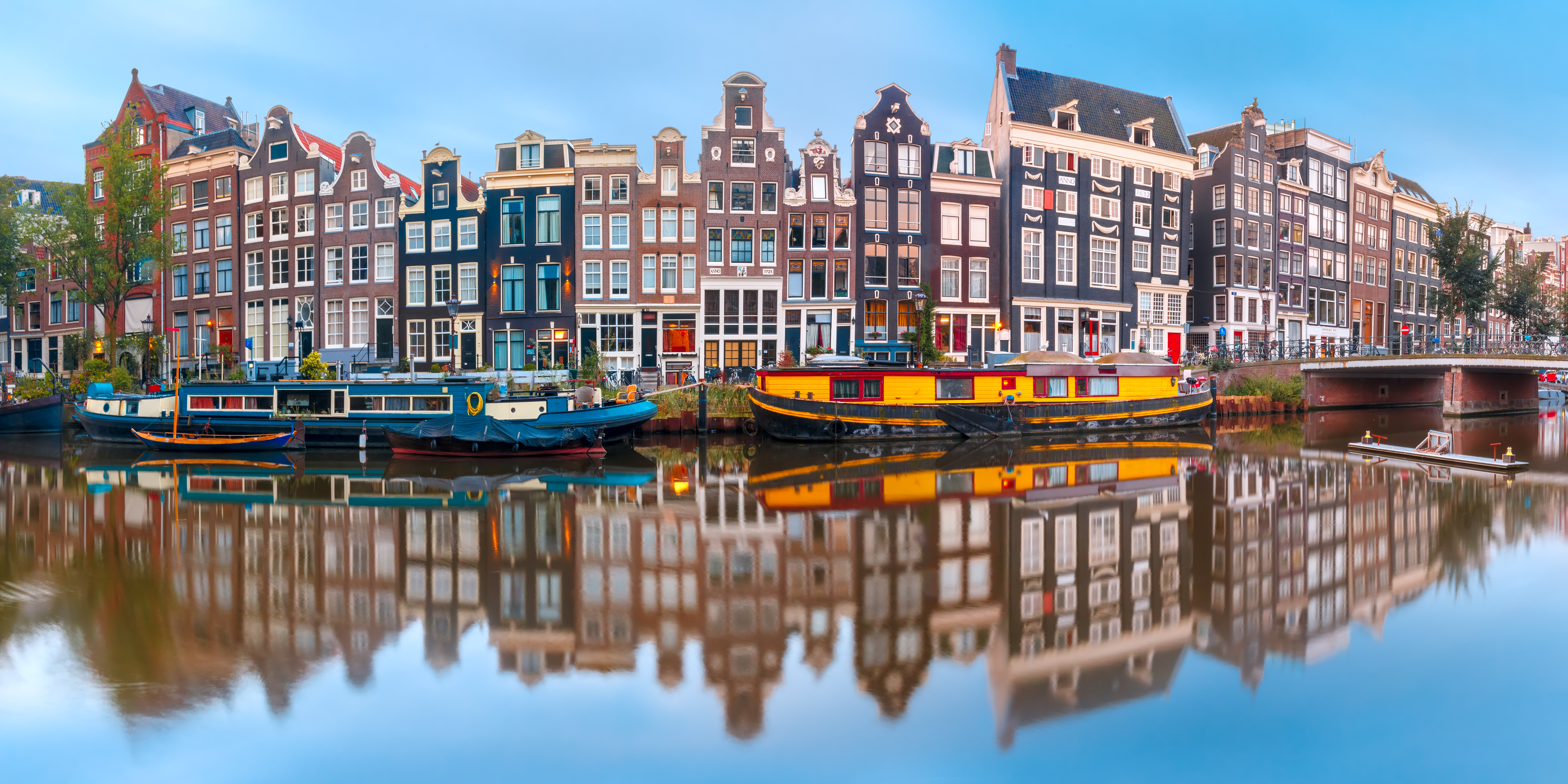 boats on the water next to a row of buildings