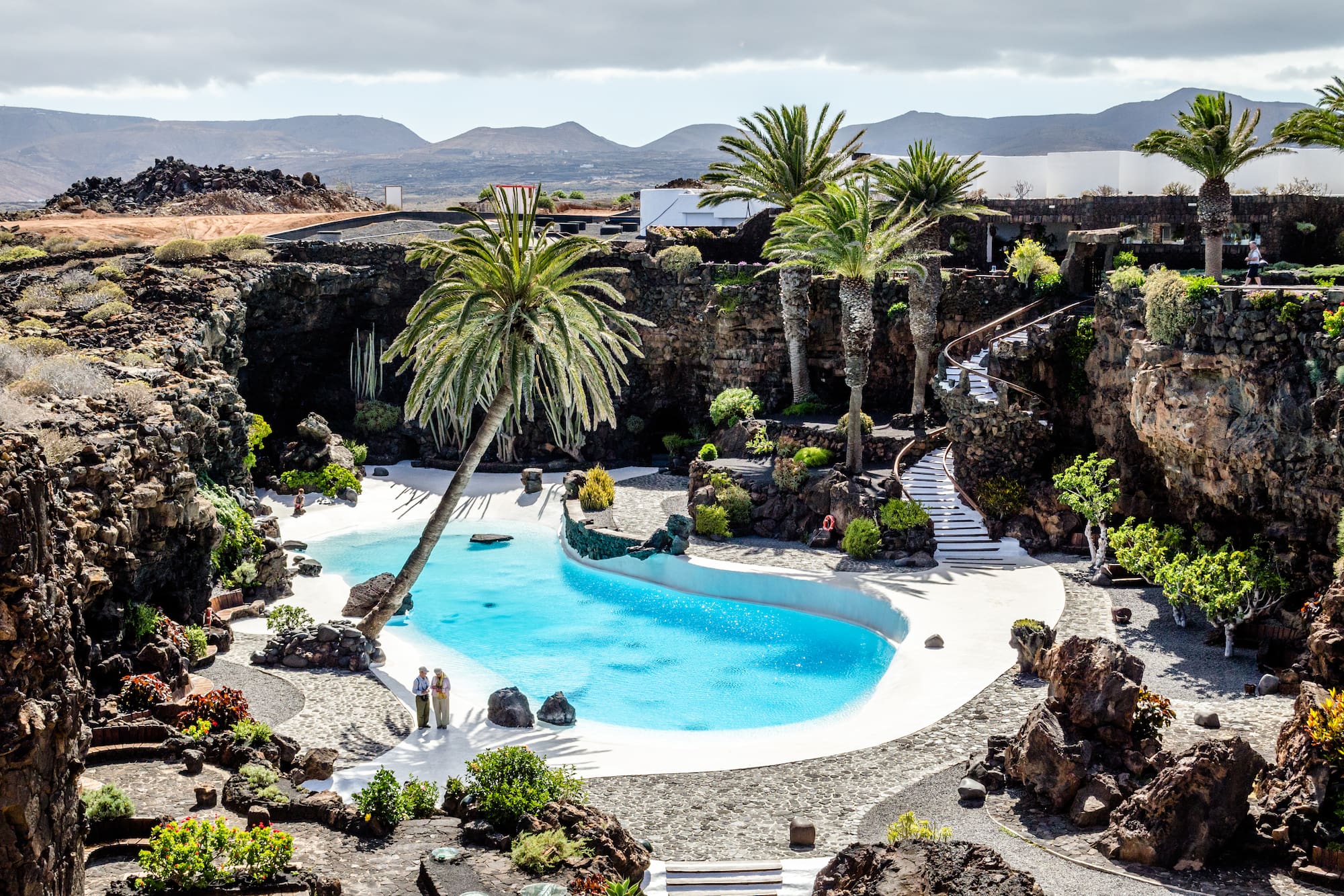 Jameos del Agua, Lanzarote: piscina natural azul, palmeras y paisaje volcánico.