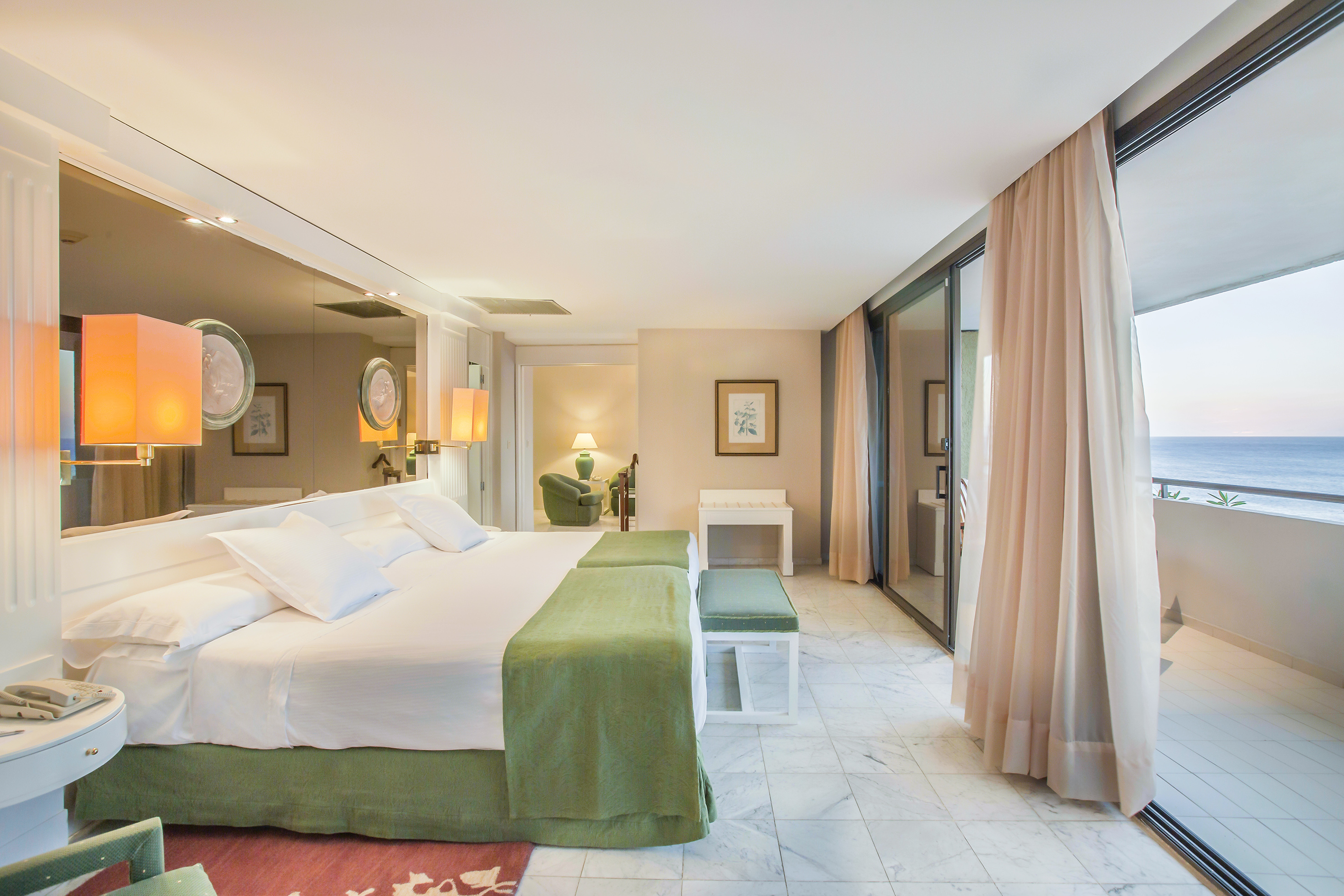 a bedroom with a large bed and a large mirror